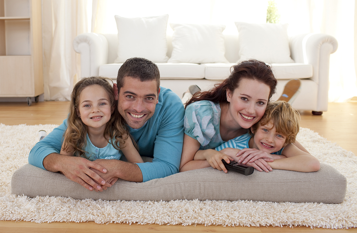 Smiling family on floor lying in living-room